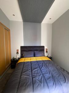 a bedroom with a large bed with blue and yellow sheets at Luxury apartment in Asilah Marina Golf in Asilah