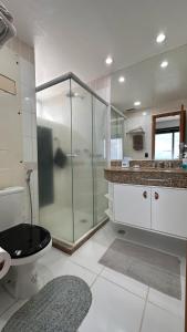 a bathroom with a glass shower and a toilet at Flat Tropical Executive in Manaus
