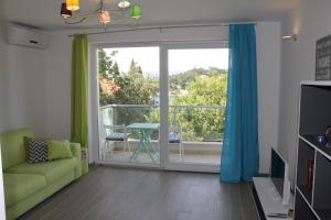 salon z kanapą i przesuwnymi szklanymi drzwiami w obiekcie Apartments Mala w mieście Cavtat