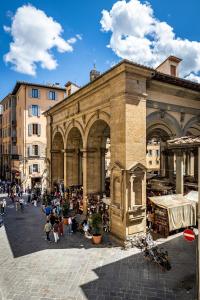 a large building with a crowd of people in front of it at La Loggia del Porcellino in Florence