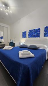un lit bleu avec des serviettes dessus dans l'établissement 41 Parallelo - Comfort rooms, à Bari