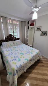 a bedroom with a bed with a floral comforter at Casa Clorophila in Vila Velha