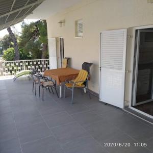 drewniany stół i krzesła na patio w obiekcie Apartmani Lucia Biograd w Biogradzie na Moru