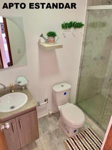 een badkamer met toilet, wastafel en douche bij Apartamentos View, calle del Malecón frente al lago in Guatapé +34 foto's