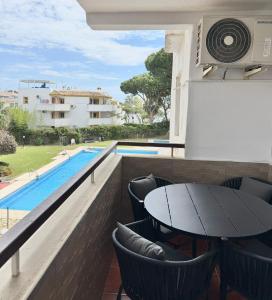a patio with a table and chairs and a swimming pool at Perfekt lokation! Gå til strand, restaurant og by in Sitio de Calahonda