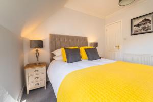 a bedroom with a yellow bed with a yellow blanket at Tigh na Drochaid, Glen Nevis - Entire Apartment in Fort William