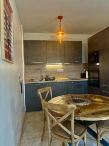 a kitchen with a wooden table and some chairs at Maisonnette bretonne typique Beg Meil Fouesnant Ty Breizh plage in Fouesnant