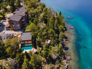 an aerial view of a house on the shore of the water at Suites Del Lago Peñon de Arelauquen, Bariloche in San Carlos de Bariloche +4 photos