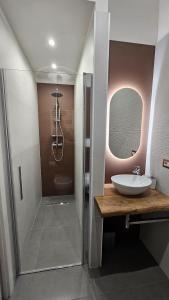 une salle de bain avec un lavabo et une douche avec un miroir dans l'établissement 41 Parallelo - Comfort rooms, à Bari