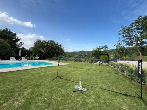 a net in the grass next to a swimming pool at Villa Santa Margherita in Chiaramonte Gulfi