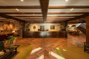 a large living room with wooden floors and a staircase at Serrazul Hotel in Gramado