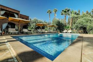 a swimming pool with chairs and umbrellas at a resort at Villa Sophia in Azib Oulad Lâdem
