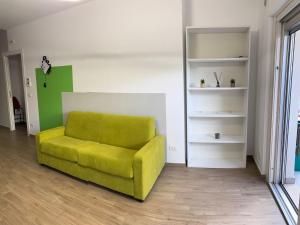 una silla verde en una habitación con un estante en Host & C, en Avezzano 3 fotos más