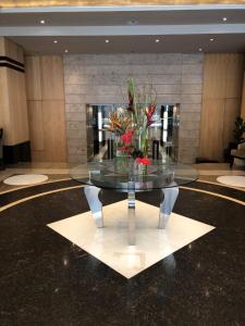 a glass table with flowers on it in a lobby at Michelangelo Towers 3Bed Apartment in Johannesburg
