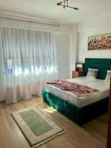 a bedroom with a bed and a large window at Clabucet View Apartment in Predeal