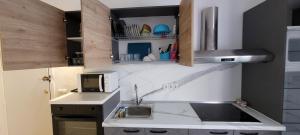 a small kitchen with a sink and a microwave at Torremolinos CARIHUELA RENOVADO - Wifi 365 Mbps - Fire Stick Amazon - Playa a 50 metros in Torremolinos