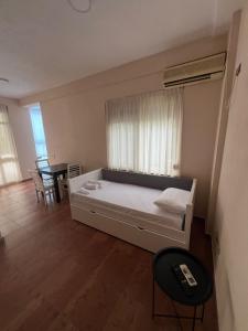 a bedroom with a bed with a window and a table at Blu Apart Hotel Durres in Durrës +30 photos