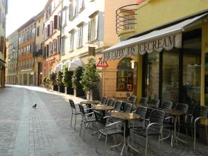 a street with tables and chairs in front of a store at Vecchia Riva in Riva del Garda