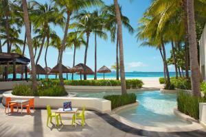 un complejo con una piscina con palmeras y una playa en Dreams Sands Cancun Resort & Spa, en Cancún