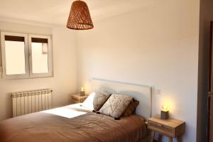 ein Schlafzimmer mit einem Bett, einem Fenster und einer Lampe in der Unterkunft Casa Vacacional el Mirador de Picos in Serdió + 21 Fotos