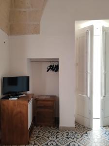a living room with a tv and a table and a door at Case Vecchie in Sogliano Cavour +22 photos