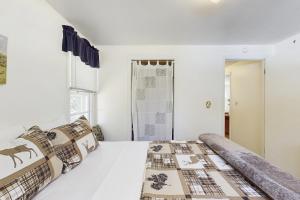 Un dormitorio con una cama con paredes blancas y una ventana. en Voyagers Cabin, en Eagle River