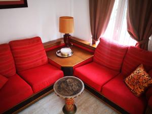 a living room with two red couches and a table at Chalet Campoamor con piscina privada in Orihuela Costa