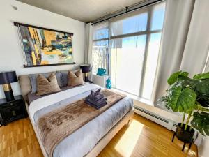 a bedroom with a large bed and a large window at Luxury Downtown Vancouver Suite in Vancouver