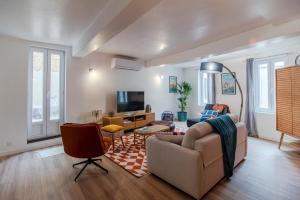 a living room with a couch and a tv at Le Baron terrasse et parking cœur de Castres in Castres