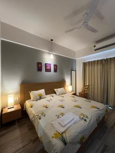 a bedroom with a large bed with two tables and two lamps at Modern Studio in City Hub in Greater Noida