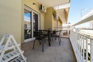 a balcony with a table and chairs on it at Styliani's Cozy Apartment in Iraklitsa