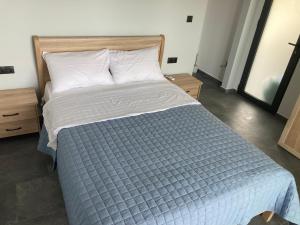 a bedroom with a bed with a blue comforter at Vassiliki in Paleros