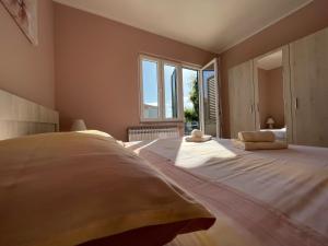 a bedroom with a large bed with two pillows on it at Apartmani Kordić in Barbat na Rabu