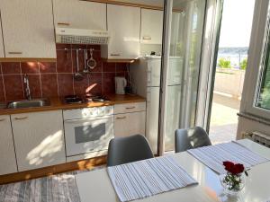 a kitchen with a table with chairs and a refrigerator at Apartmani Kordić in Barbat na Rabu +38 photos