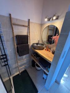un baño con lavabo y espejo en Un Chalet au Verger, en Conteville
