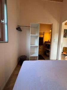 Habitación con cama y estante para libros en Un Chalet au Verger, en Conteville