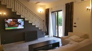 a living room with a couch and a tv on a wall at Villa Mosè Apartment, parking, terrace in Villaggio Mosè
