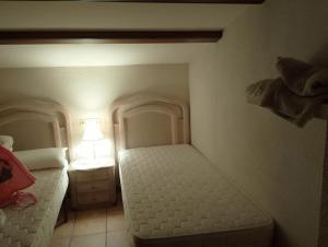 a small bedroom with two beds and a lamp at Mas Martí in Solíus