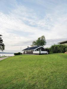 a black and white house with a large grass field at Holiday Home With Fjord Views In Hjarbæk in Løgstrup
