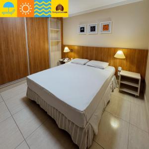 a bedroom with a large white bed in a room at Piazza diRoma com acesso ao Acqua Park - Temporada CN in Caldas Novas