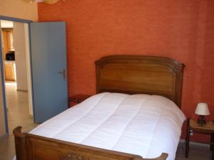 Ce lit se trouve dans une chambre dotée d'un mur orange. dans l'établissement Gite PROVENCE MONT VENTOUX, à Malemort-du-Comtat