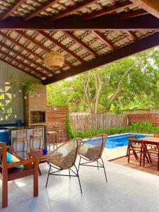 a patio with chairs and a table and a pool at Casa bem localizada em BG in Barra Grande