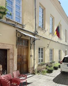 Un edificio con una bandera y sillas delante. en Pilies8 Luxury Vilnius Apartment, en Vilna
