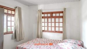 ein Schlafzimmer mit einem Bett und einem Fenster in der Unterkunft Casa em Navegantes próxima a Praia da Miraguaia in Navegantes