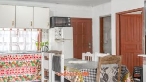 eine Küche mit Tisch und Stühlen und einem Kühlschrank in der Unterkunft Casa em Navegantes próxima a Praia da Miraguaia in Navegantes