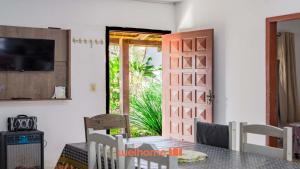 ein Esszimmer mit einem Tisch und einer Tür in der Unterkunft Casa em Navegantes próxima a Praia da Miraguaia in Navegantes