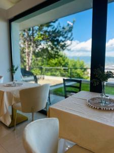 two tables and chairs in a room with a large window at Resident Apartments Nota in Skopje +61 photos