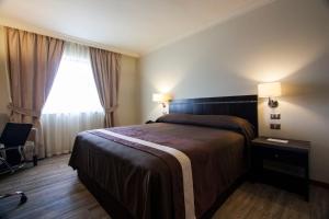 um quarto de hotel com uma cama e uma janela em Hotel Diego de Almagro Osorno em Osorno