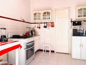 eine Küche mit weißen Schränken und einem Herd mit Backofen in der Unterkunft Casa Luna in Mexiko-Stadt