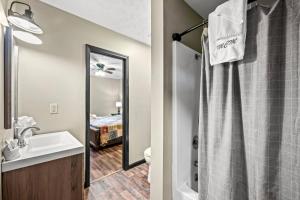 ein Badezimmer mit Waschbecken, Toilette und Spiegel in der Unterkunft Secluded~ 3 Kings~ Games~ Hot Tub + Fire Pit~ Pets in Cove Creek Cascades + 33 Fotos